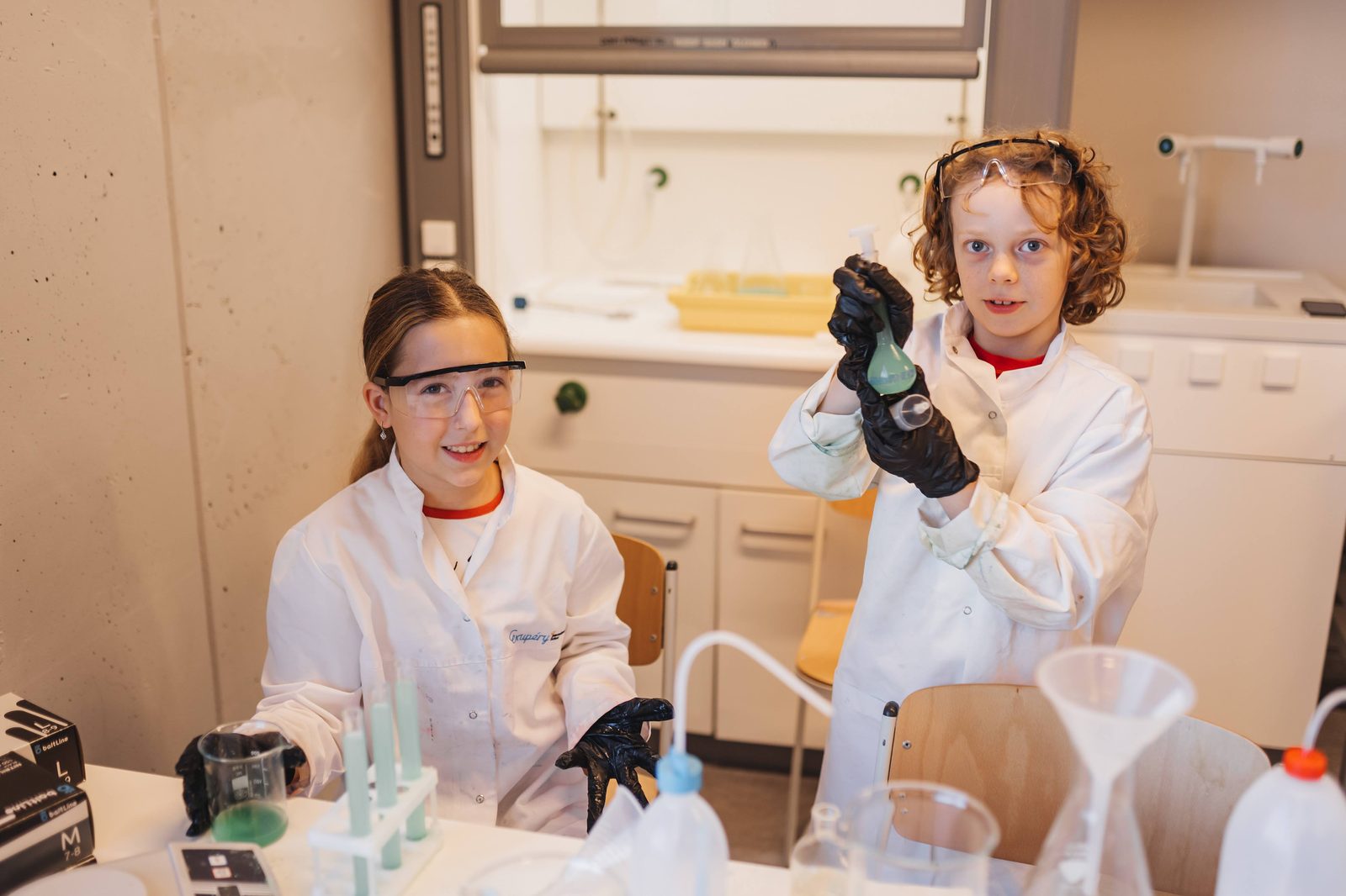 Campers in lab coats running an experiment during MetaMind, EIS Campus