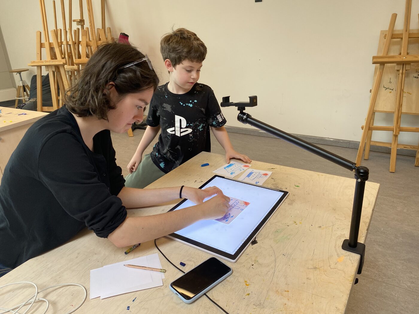 A camper drawing on a light table with an instructor, Animation Studio, Exupery Camp