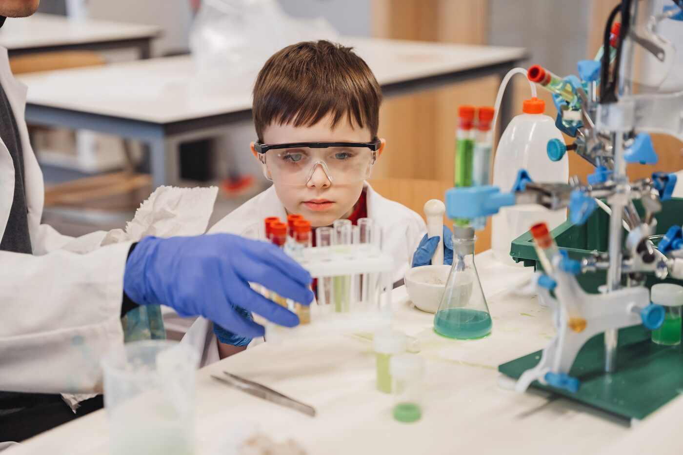 A camper running a lab experiment with test tubes, Science Lab, Exupery Camp